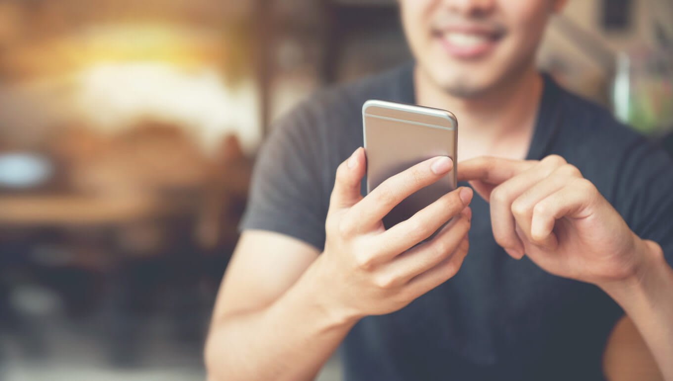 Happy man using his phone.